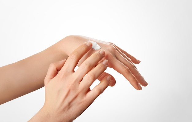 Photo healthy handsfemale applying moisturizer to her hands after bathskincare concept