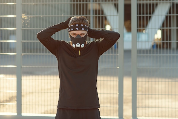 Healthy and handsome young man running at the cityspace the man wearing a respirator for cardio