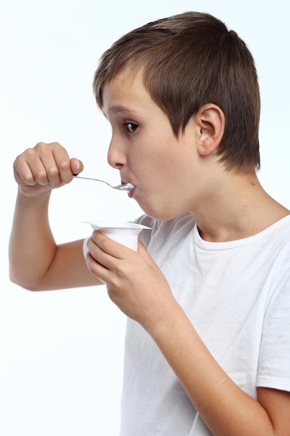 Healthy happy boy eating yogurt