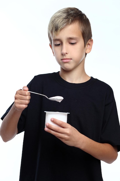 Healthy happy boy eating yogurt