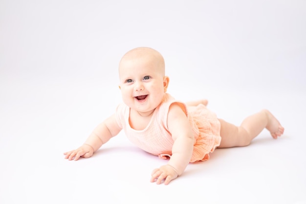 A healthy happy cute baby lies on his stomach and looks at the camera