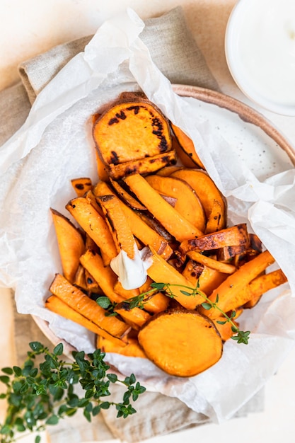 Photo healthy homemade baked sweet potato wedges with cream dip sauce and herbs healthy snack