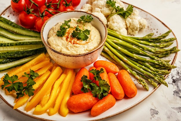 Healthy homemade hummus with assorted fresh vegetables.