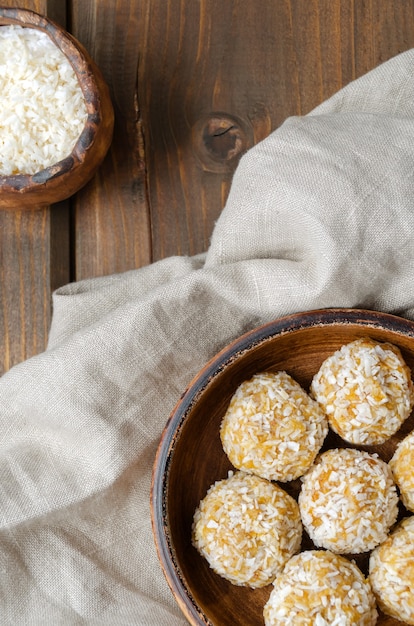 Photo healthy homemade sweet energy balls of dried fruits and nuts in coconut.