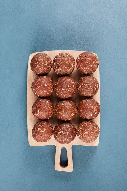 Healthy homemade sweets on wooden cutting board, top view. Energy balls are a healthy snack.