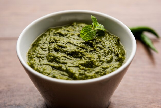 Healthy Indian Green Chutney or Sauce Made using Coriander, Mint And Spices. isolated over moody background. Selective focus