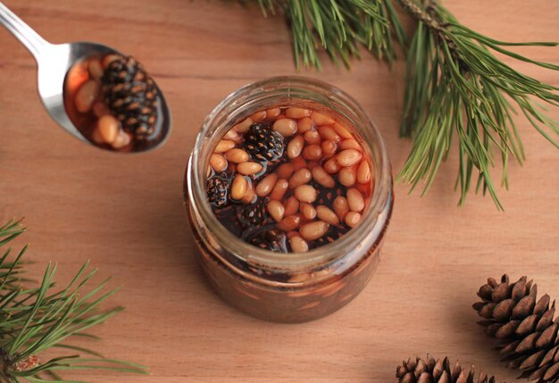 Healthy jam from pine cones with pine nuts on a beige background
