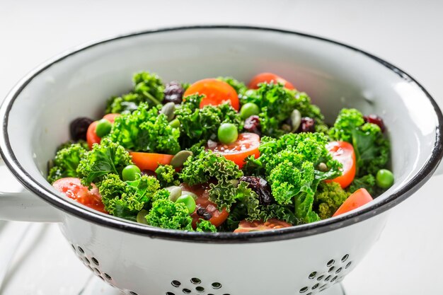 Healthy kale salad with green peas and cherry tomatoes