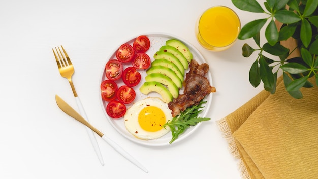 건강한 케토 조식 계란 아보카도 아루굴라 토마토와 베이컨