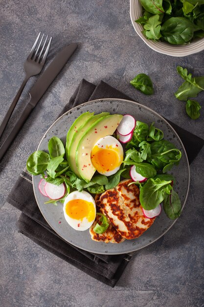 건강한 케토 팔 레오 다이어트 아침 식사 : 삶은 계란, 아보카도, 할루 미 치즈, 샐러드 잎