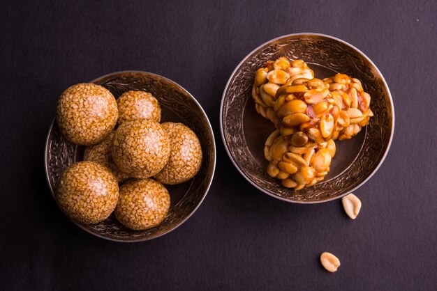 Photo healthy laddoo using roasted peanuts, sesame and split daliya with jaggery, served in a wooden plate, selective focus