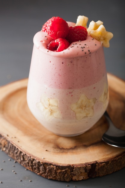 Healthy layered raspberry and banana smoothie in glass