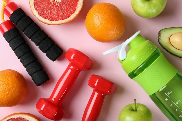 Healthy lifestyle accessories on pink background, top view