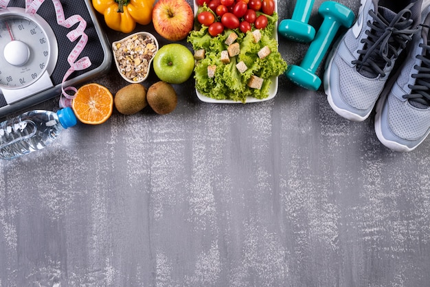 Healthy lifestyle, food and sport accesories on gray 