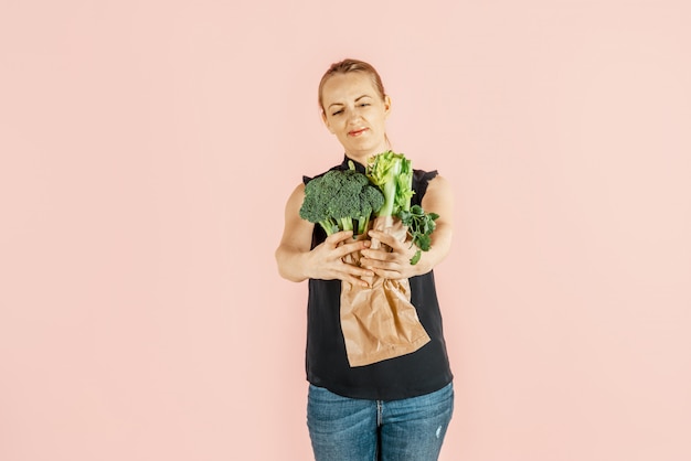 健康的な生活様式。女の子はブロッコリーと緑の野菜を手に持っています。食事と適切な栄養。 。