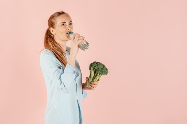 健康的な生活様式。女の子はブロッコリーと緑の野菜を手に持っています。食事と適切な栄養。 。