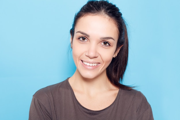 Stile di vita sano, felicità e concetto di persone - bella donna sorridente su sfondo blu.