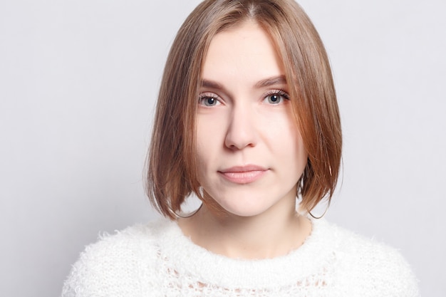 Healthy lifestyle, happiness and people concept - Young beautiful cute girl showing different emotions. Background for girl a concrete gray wall. Laughing, smiling, anger, suspicion, fear, surprise.