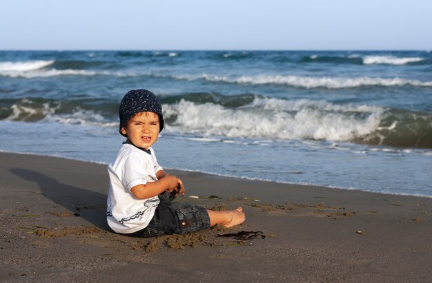 健康的な生活様式。小さな男の子が海岸を歩いて遊んでいます。