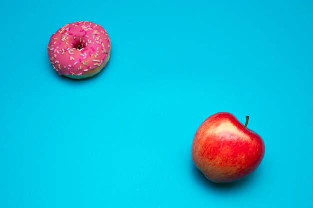 Healthy lifestyle or nutrition concept. Dilemma between healthy good fresh fruit and sweets with a lot of sugar and calories.