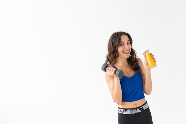Healthy lifestyle, people and sport concept - Woman with healthy juice drinking for sport and fitness on white background with copy space