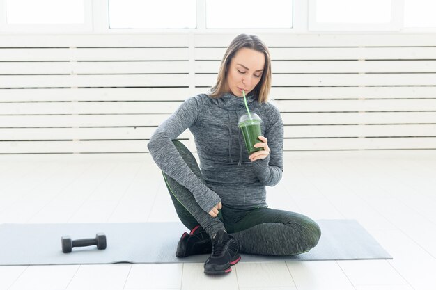 Healthy lifestyle, people and sport concept - Woman with healthy juice drinking for sport