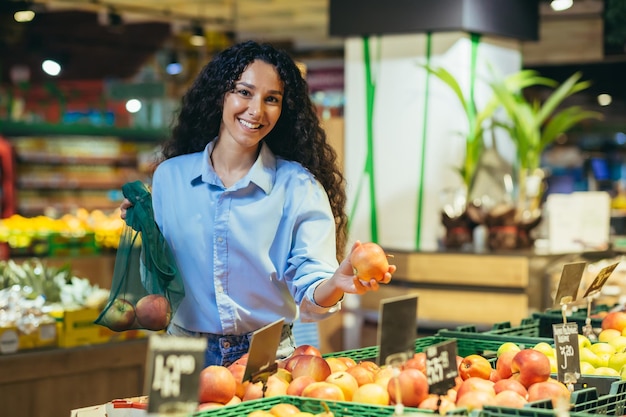 Healthy lifestyle young beautiful latin american girl student vegetarian chooses and buys apples in