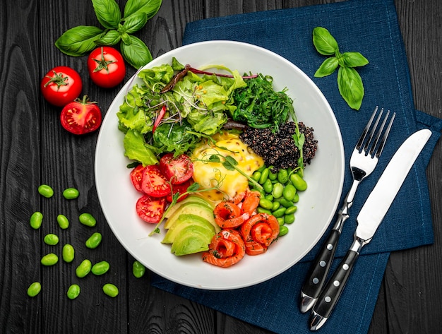 Healthy light breakfast with poached egg salmon avocado tomato\
lettuce and chia seeds business lunch serving food in a restaurant\
healthy food concept photo for the menu