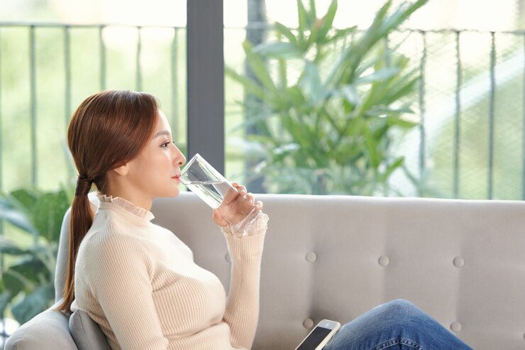 Photo 健康的な液体。ガラス、自由空間からきれいな水を飲むアジアの女の子
