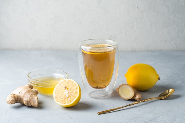 Tè al miele al limone e tè alle erbe con radice di zenzero su una superficie grigia