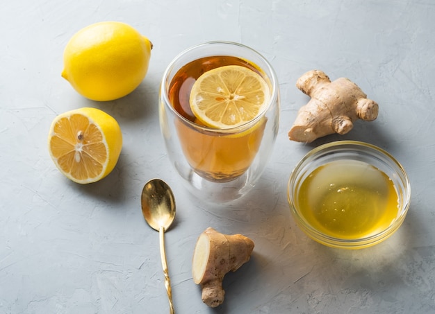 Healthy living herbal tea lemon honey tea with ginger root on a gray surface