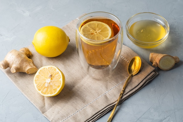 Healthy living herbal tea lemon honey tea with ginger root on a grey surface