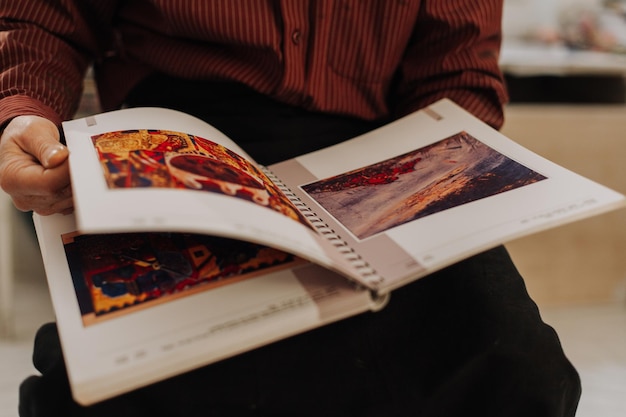 L'uomo anziano dall'aspetto sano è alla fine degli anni '70 seduto in giardino a casa e legge un libro all'aperto