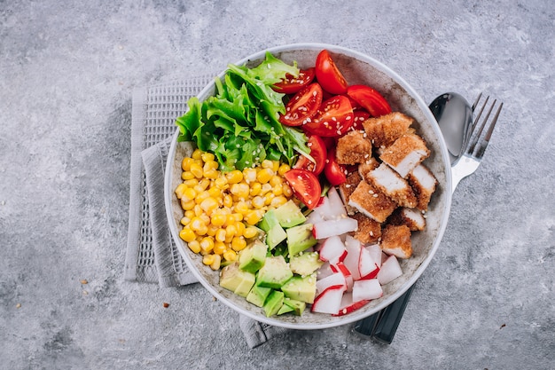 건강한 도시락. 아보카도, 닭고기, 토마토, 무, 옥수수, 녹색 잎 야채 샐러드.