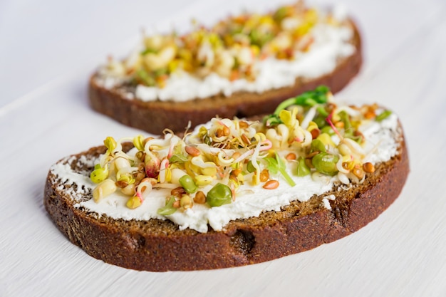 Healthy macrobiotic breakfast. Sandwich with cream cheese, peas microgreens and sprouted mung beans