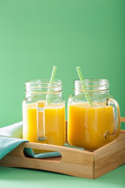 Healthy mango pineapple smoothie in mason jars