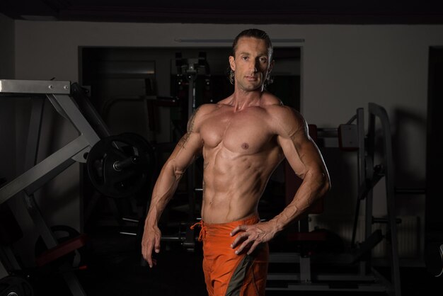 Healthy Mature Tattoo Man Standing Strong In The Gym And Flexing Muscles  Muscular Athletic Bodybuilder Fitness Model Posing After Exercises