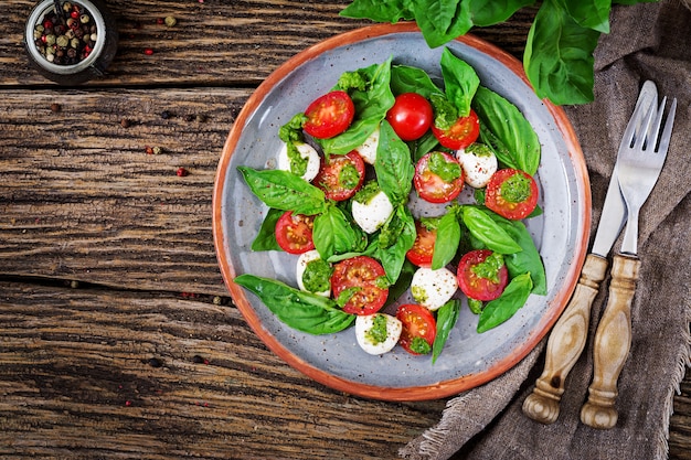 Pasto sano con pomodorini, palline di mozzarella e basilico.