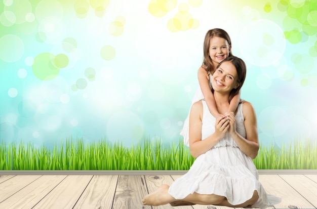 Healthy mother and baby girl pointing while sitting on beach in the evening