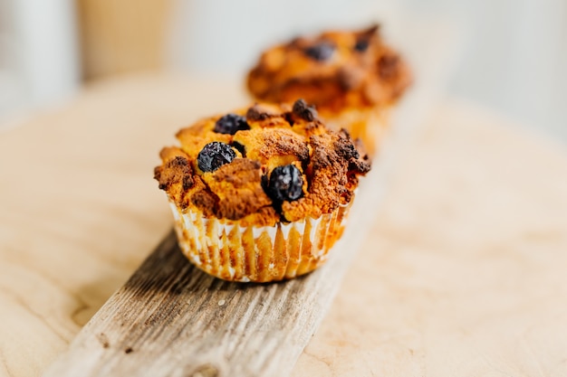 Photo healthy muffins with coconut flour and blueberries on light wooden plate decorated with mint an conc