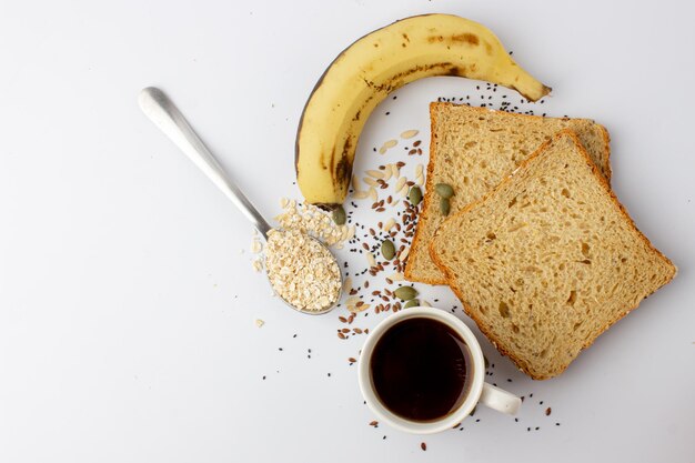 Healthy multigrain bread with pumpkin chia flax seeds banana black coffee and oats spoon