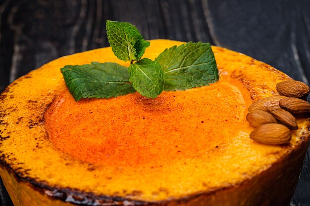 Zuppa di crema di zucca con cibo naturale sano su fondo di legno nero