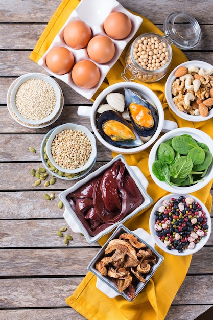 Healthy nutrition dieting concept. Assortment of foods high in iron. Beef liver, spinach, eggs, legumes, nuts, mushrooms, quinoa, sesame, pumpkin seeds, soy beans, seafood. Copy space, flat lay