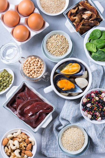 Healthy nutrition dieting concept. Assortment of foods high in iron. Beef liver, spinach, eggs, legumes, nuts, mushrooms, quinoa, sesame, pumpkin seeds, soy beans, seafood. Flat lay