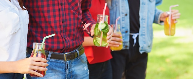Фото Здоровое питание. друзья пьют свежий сок детокс на фоне зеленой природы.