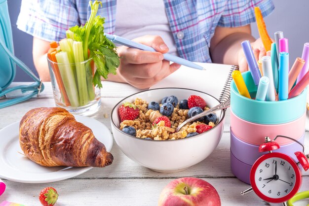 healthy nutritious morning breakfast for school kids with fresh fruits vegetables croissant muesli milk and sandwich child girl having breakfast before school and work copy space