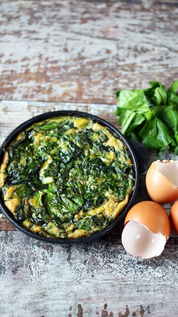 Photo healthy omelet with spinach in a pan.