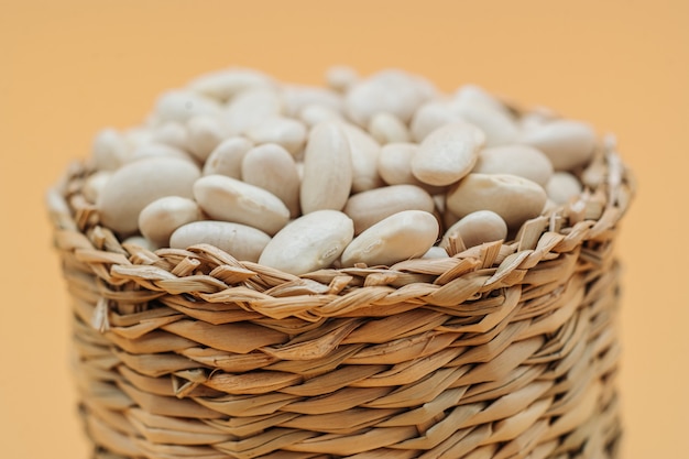 Healthy organic dried white beans in a straw basket