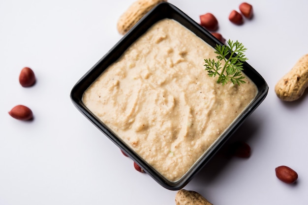 Healthy Peanut chutney made using Groundnut or Shengdana or mungfali. served in a small bowl with raw whole. Selective focus