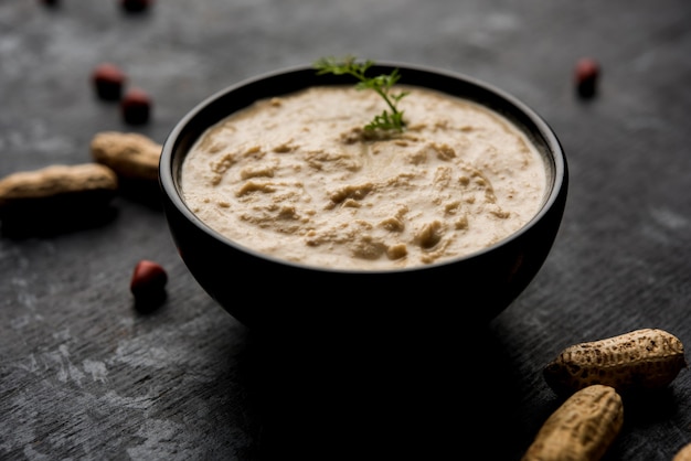 Healthy Peanut chutney made using Groundnut or Shengdana or mungfali. served in a small bowl with raw whole. Selective focus